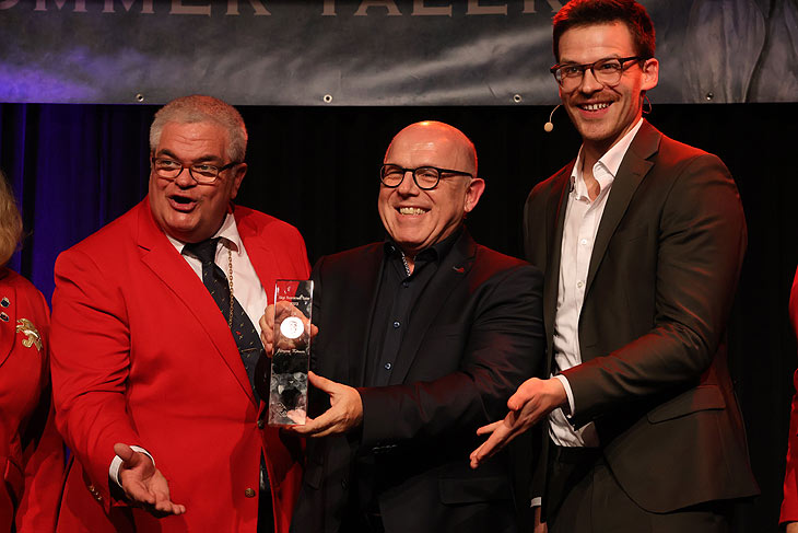 Jürgen Kirner ist Preisträger 2023 des Sigi Sommer Taler, links Narrhalla Präsident Günther Grauer, rechts Laudator Martin Frank (ªFoto:Martin Schmitz)